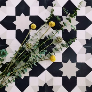 Carreau de ciment véritable motif étoile noir et blanc CARODECO 7590-1 avec fleurs jaunes sur fond graphique
