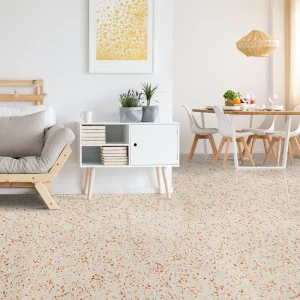 Terrazzo PP12 Carodeco fond beige clair avec éclats terracotta, posé au sol dans un salon et salle à manger lumineux
