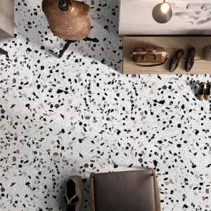 Terrazzo PPG33 Carodeco fond gris clair avec éclats noir, blanc et beige, posé au sol dans un intérieur contemporain