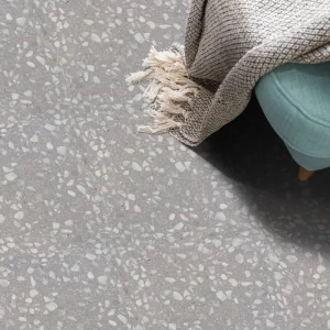 Terrazzo PPG45 Carodeco fond gris clair avec éclats de marbre blancs, posé au sol dans un intérieur moderne
