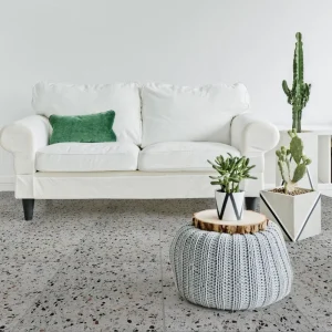 Terrazzo Roma Carodeco fond gris clair avec éclats noir, blanc et ocre, posé au sol dans un salon moderne lumineux